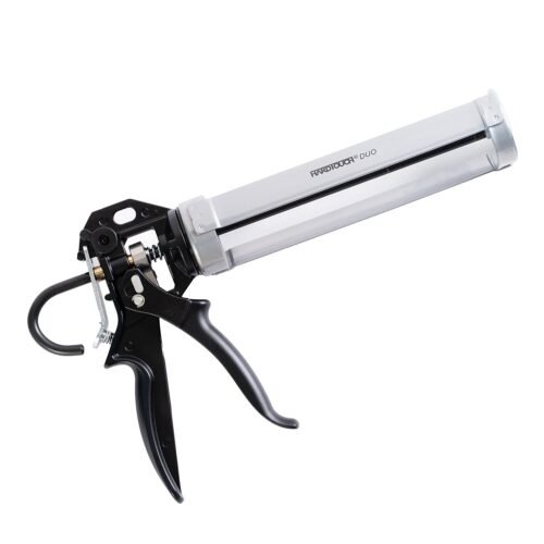 A silver and black caulking gun placed on a surface, with a pair of scissors nearby.